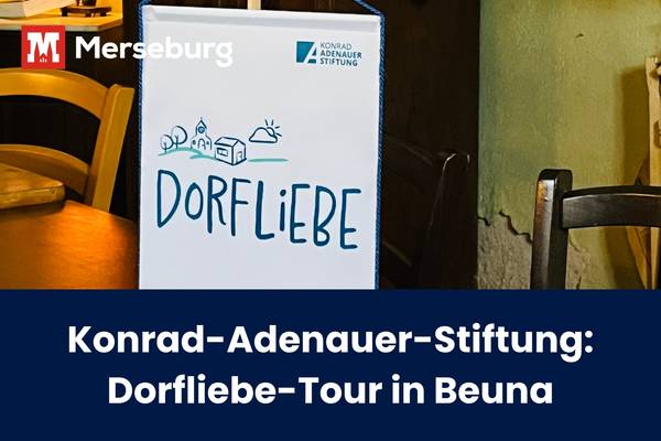 Das Plakat der Dorfliebe-Tour hinter einem kleinen, runden Esstisch